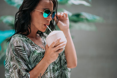 Young woman drinking water from coffee