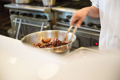 Midsection of chef preparing food in kitchen