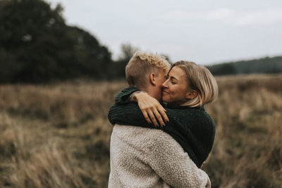 Rear view of couple holding hands on field