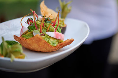 Original dish with avocado papaya mango cherry tomatoes and mint leaves