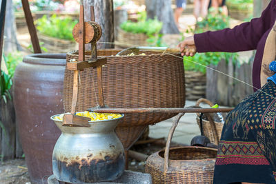 Midsection of woman working by wicker baskets