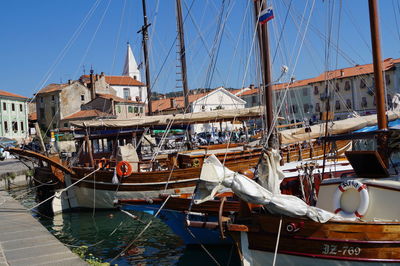 Boats moored at harbor against sky