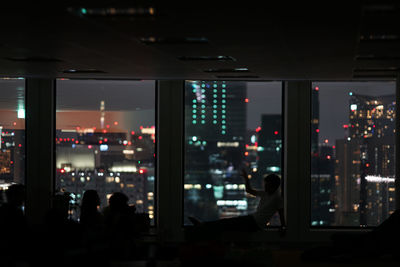 Silhouette people in illuminated city at night