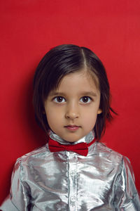 Christmas portrait of a 4 year old boy in a silver shirt and a red bow tie