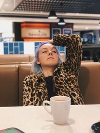 Portrait of woman with coffee cup on table