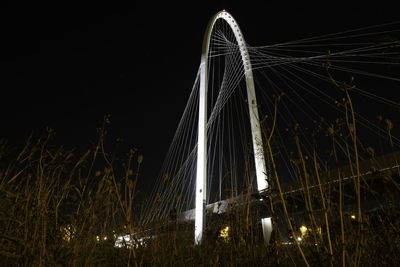 Low angle view of illuminated bridge against sky at night