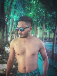 Young man wearing sunglasses standing on land