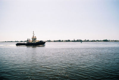 Ship sailing in sea against clear sky