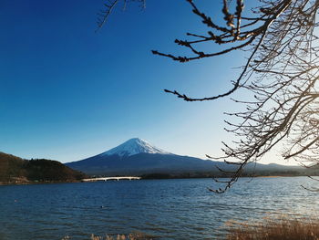 Scenic view of lake and mountains against blue sky