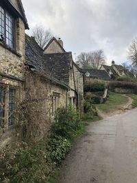 Old building by road against sky