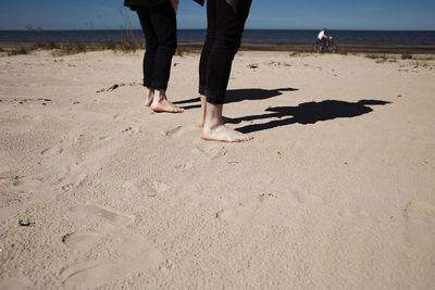 Low section of people standing on beach