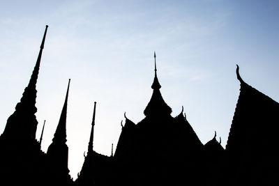 Low angle view of silhouetted roof of temples at dusk