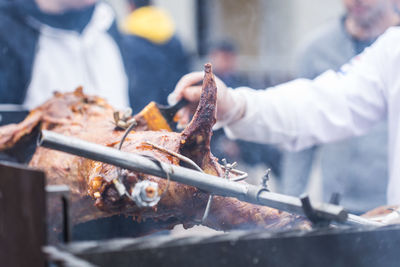 Close-up of man preparing food on barbecue grill