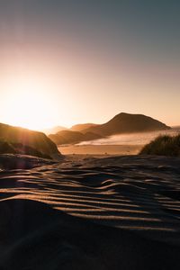 Scenic view of land against clear sky during sunset