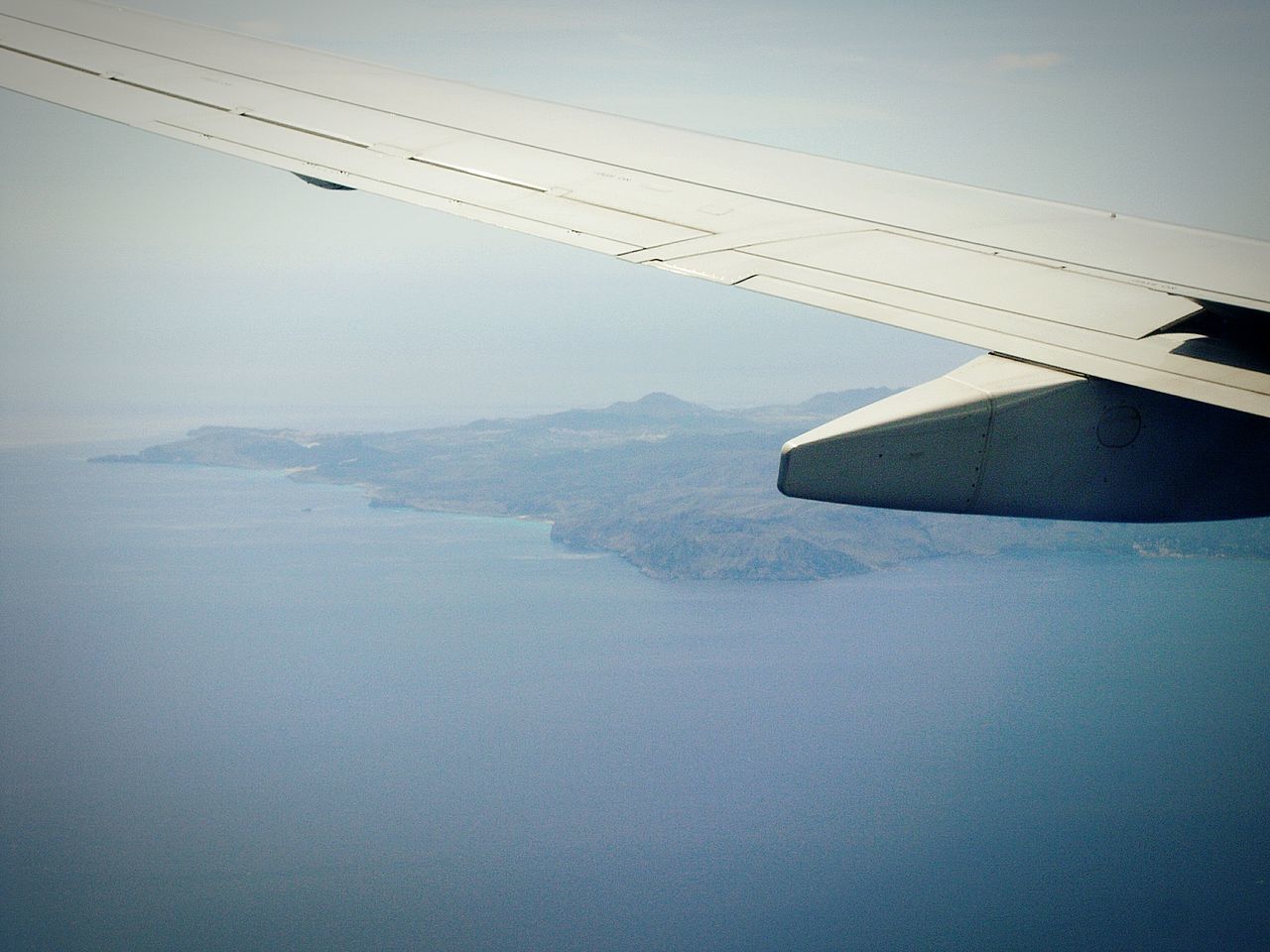 flying, airplane, aircraft wing, air vehicle, transportation, mode of transport, part of, mid-air, cropped, aerial view, scenics, landscape, travel, sky, mountain, journey, nature, tranquil scene, beauty in nature, on the move