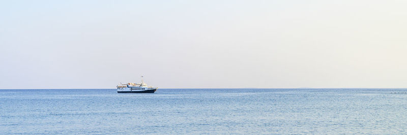 Sailboat sailing on sea against clear sky