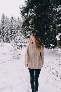 Woman standing on snow covered field