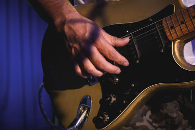 Midsection of man playing guitar