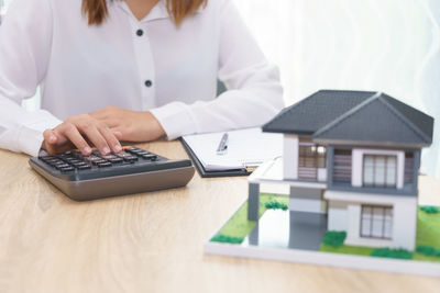 Midsection of woman using laptop on table