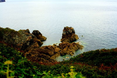 High angle view of rock formation in sea against sky