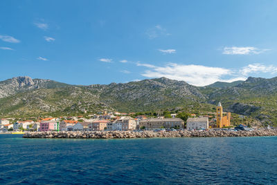 Scenic view of sea by buildings against sky