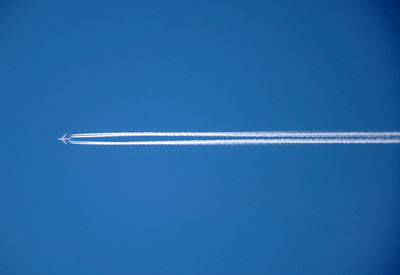 Low angle view of vapor trail against blue sky