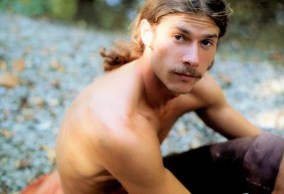 Portrait of shirtless man sitting outdoors