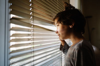 Portrait of young woman looking away at home