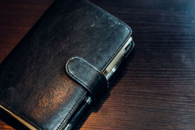 High angle view of black diary on wooden table