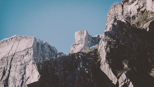 Low angle view of rocky mountains against clear sky