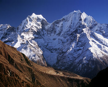Scenic view of snowcapped mountains against clear sky