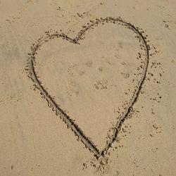 Close-up of heart shape on sand