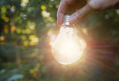 Close-up of hand holding illuminated lighting equipment