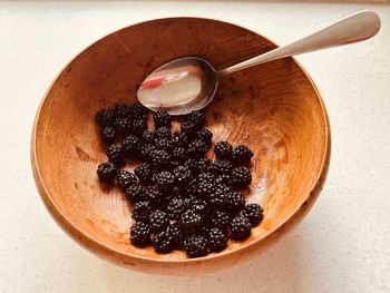 Blackberries and  stainless steel spoon in  wooden bowl. foraged, locally sourced, nutritious fruit.