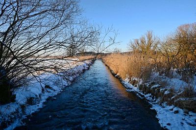 Snow covered landscape against clear sky