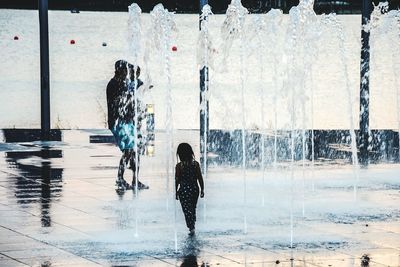 Rear view of a girl playing in fountain