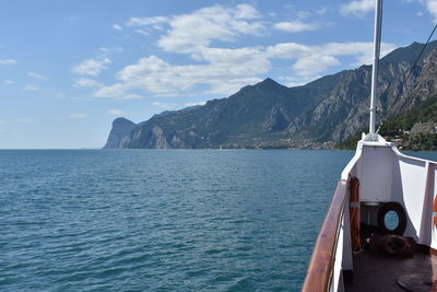 Scenic view of sea by mountains against sky