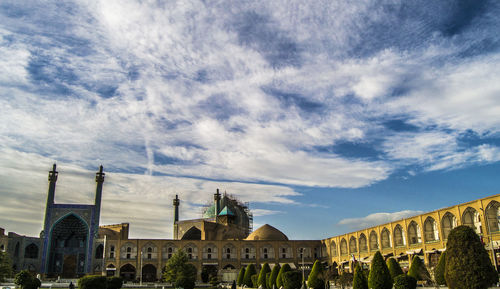 Low angle view of buildings against cloudy sky