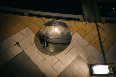 Low angle view of illuminated light bulb hanging on ceiling
