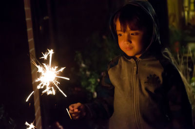 Close-up of hand holding sparkler at night