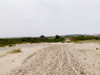 Surface level of dirt road against sky