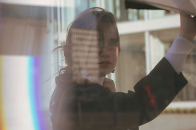 Portrait of woman seen through glass window