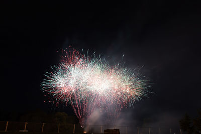 Low angle view of firework display at night