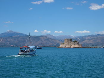 Ferry sailing towards bourtzi sea castle in nafplio against sky