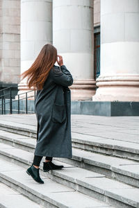 Full length of woman standing on staircase