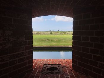 View of fort against sky seen through window