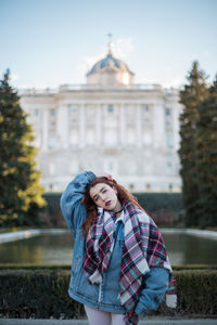 Portrait of woman standing against historic building