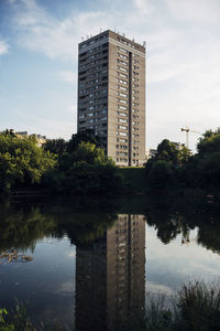 Reflection of building in lake against sky