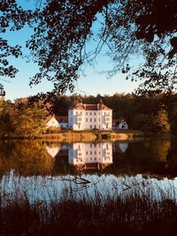 Houses by lake against sky