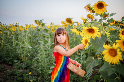 Portrait of woman with arms outstretched standing on field